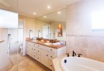 The bathroom features a walk-in shower and deep soaking tub